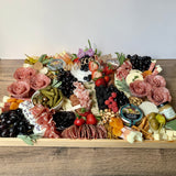 Charcuterie board with meats, cheeses, fruit, olives, nuts and accompaniments to feed 20-25 as appetizer portions. The Graze To-Go.