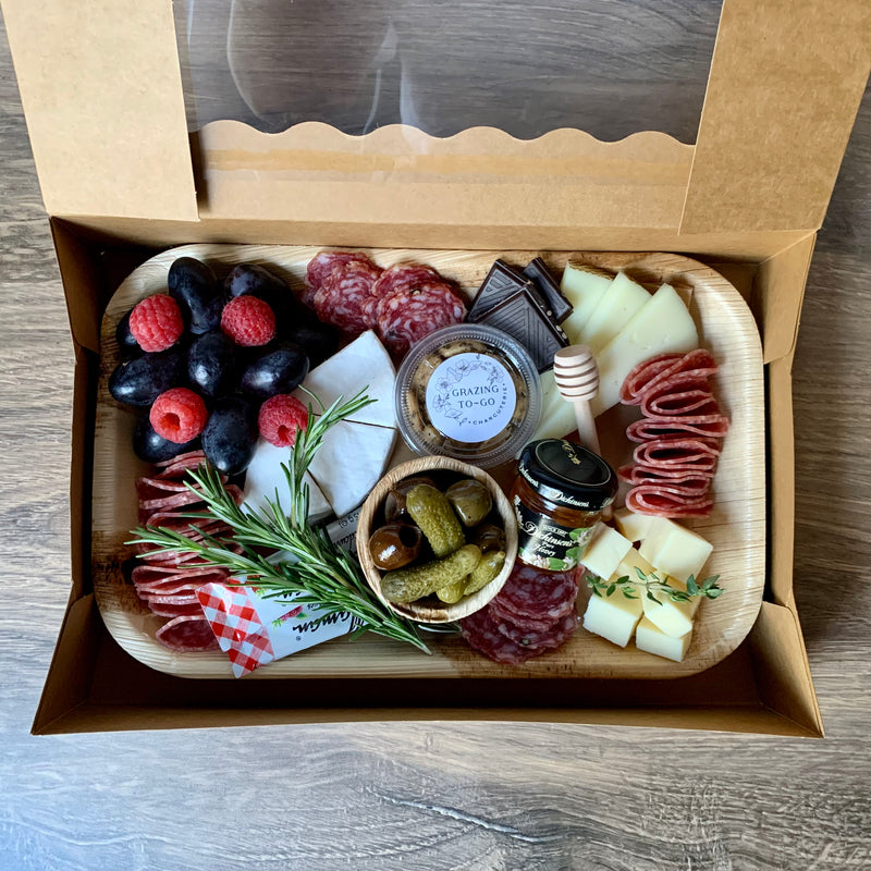 Charcuterie meats, cheeses, fruit, nuts, olives, pickles and accompaniments on a tray inside a Kraft box. Serves 2-3 as appetizer portions. The Wine Taster.