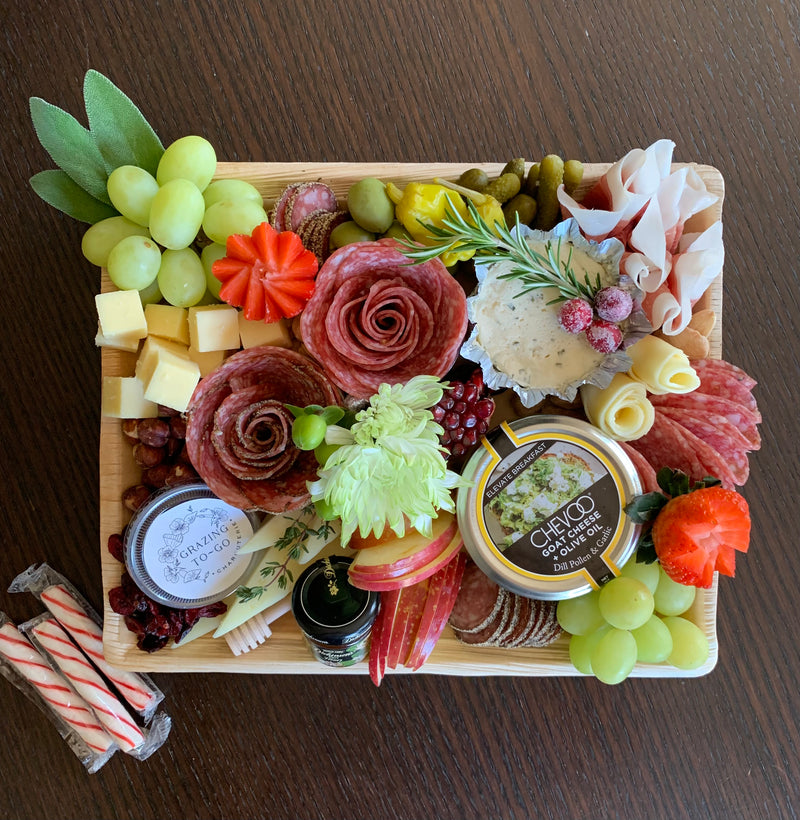 Charcuterie meats, cheeses, fruit, nuts, olives, pickles and accompaniments on a tray inside a Kraft box. Serves 4-6 as appetizer portions. The Get-together.