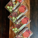Charcuterie meats, cheeses, fruit, nuts, olives, pickles and accompaniments on a tray inside a Kraft box with lid for easy travel. Serves 1-2 as appetizer portions. The Travel Box.