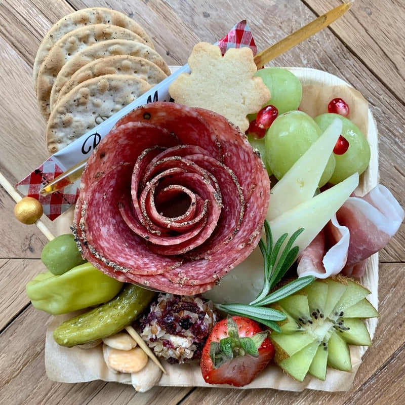 Charcuterie meats, cheeses, fruit, nuts, olives, pickles and accompaniments on a tray inside a Kraft box. Serves 1-2 as appetizer portions. The Mini Graze.